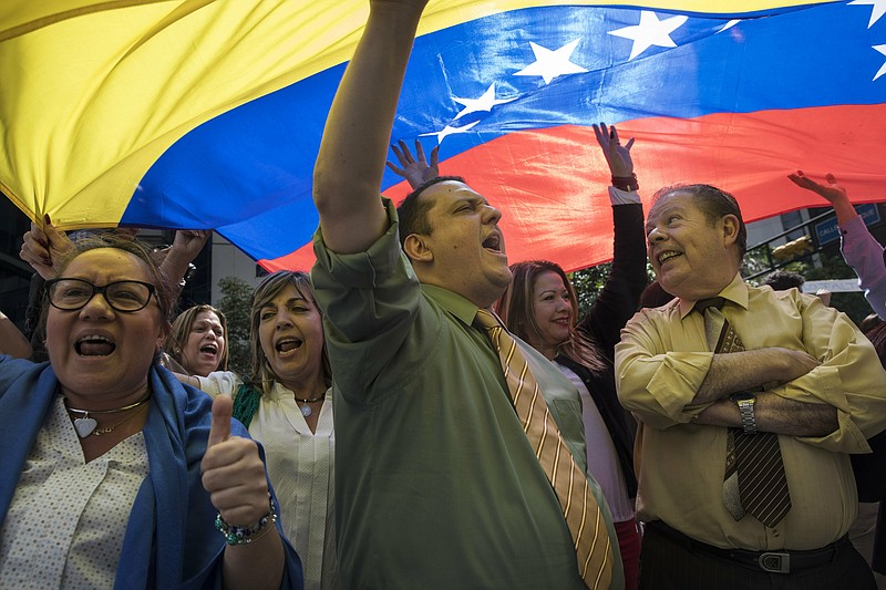 People chant "Free elections" in a walk out against President Nicolas Maduro, in the financial district of Caracas, Venezuela, Wednesday, Jan. 30, 2019. Venezuelans are exiting their homes and workplaces in a walkout organized by the opposition to demand that Maduro leave power. (AP Photo/Rodrigo Abd)