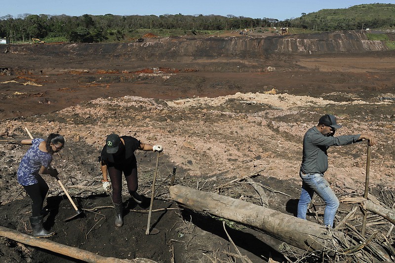 Tereza Ferreira Nascimento, center, her sister-in-law Sonia Santos, left, and her brother Pedro Ferreira dos Santos dig with garden tools in search of the body of Tereza's and Pedro's missing brother Paulo Giovane Santos, days after a mining company's dam collapsed in Brumadinho, Brazil, Wednesday, Jan. 30, 2019. "We are here since Friday taking turns between brothers, brothers-in-law, searching for the body so that we can at least give him a dignified burial,” said Nascimento, holding back tears. “So far it has been in vain.” (AP Photo/Andre Penner)