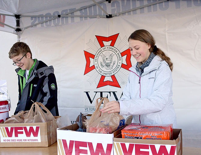 Tradd McLerren, 12, and his sister Tarrah, 14, organize donations Friday in front of Capitol Plaza Hotel. Volunteers and veterans collected canned foods, non-perishable items, and diapers and baby wipes to help military families and veterans in need. The food drive will continue from 9 a.m.-3 p.m. today outside of the hotel.