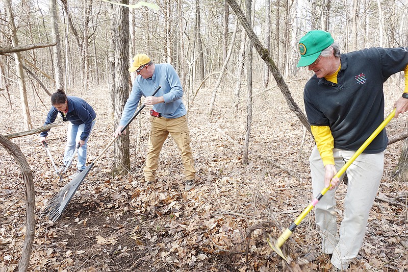 From left, volunteers Brandi Bergthold, Jim Bell and Cary Maloney clear out a wooded area Sunday at Binder Park where they hope to construct a new children's mountain bike trail. The Jefferson City Trail Users and Osage Region Trail Association hope to open the trail up by this summer.