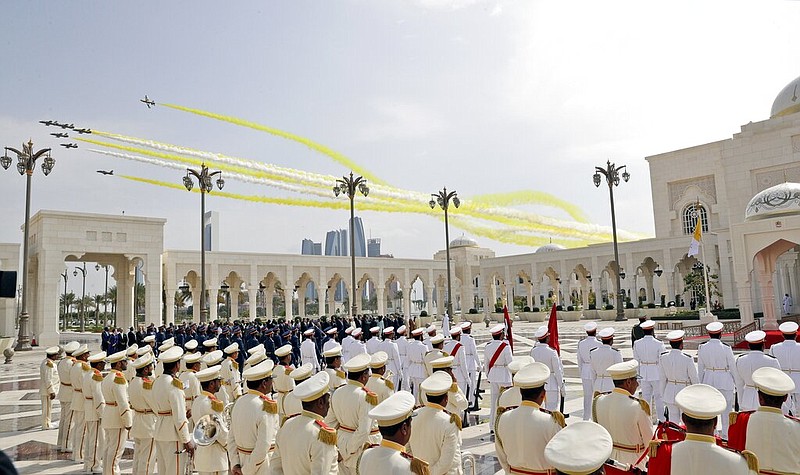 Yellow and white smoke, the colors of the Vatican flag, trail behind military aircrafts flying over the Presidential Palace during an official an official welcome ceremony for Pope Francis, in Abu Dhabi, United Arab Emirates, Monday, Feb. 4, 2019. Francis has arrived at the presidential palace to officially start his historic visit to the United Arab Emirates as canons boomed and a military aircraft flew over trailing the yellow and white smoke of the Holy See flag.