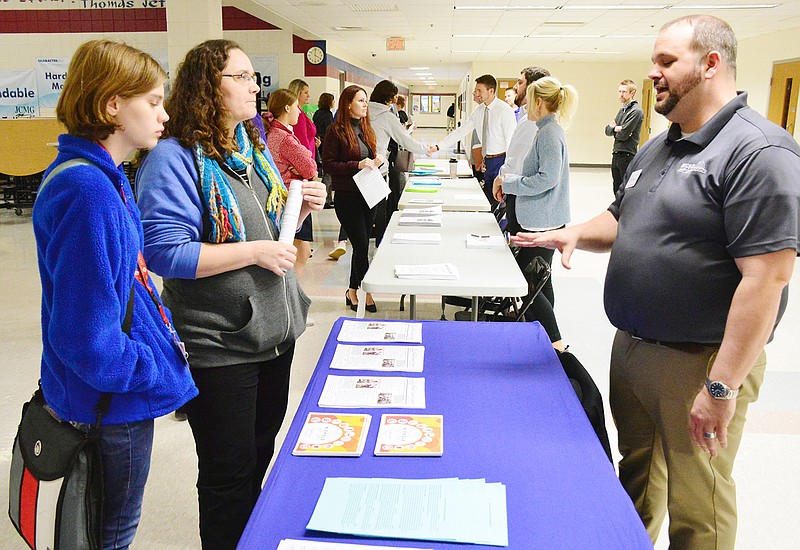 Soon-to-be Capital City High School freshman Casandra Schroer and her mother, Heather, ask Cody Bashore, assistant director at Nichols Career Center, questions about computer science and robotics classes Tuesday evening at Thomas Jefferson Middle School during orientation night for the first freshmen class at the new school.