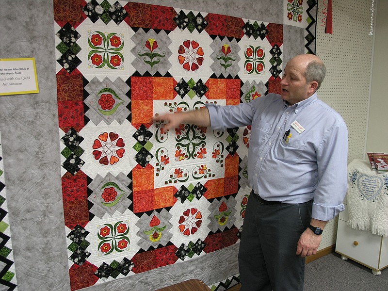 Timothy Hoover shows off the details in a quilt made on a Bernina sewing machine.