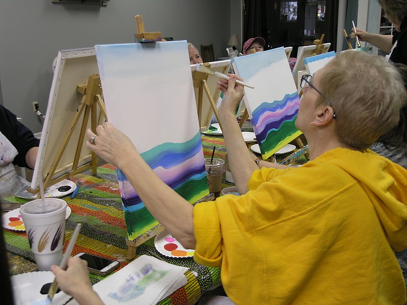 Karen Wood works on the background of her painting Jan. 31, 2019, at the Sip and Paint event.