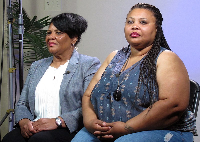FILE - In this June 7, 2018 file photo, Alice Marie Johnson, left, and her daughter Katina Marie Scales wait to start a TV interview on in Memphis, Tenn. Johnson, an inmate whose life sentence was commuted thanks in part to the efforts of Kim Kardashian West, now has a book deal, along with a deal for film and television rights. Harper, an imprint of HarperCollins Publishers, announced Wednesday, Feb. 6, 2019, that Johnson's "After Life: My Journey From Incarceration to Freedom" comes out May 21. (AP Photo/Adrian Sainz, File).