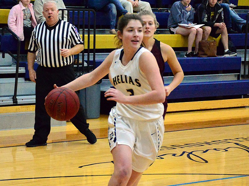 Helias guard Catherine Conley dribbles toward the basket during Wednesday night's game against School of the Osage at Rackers Fieldhouse.