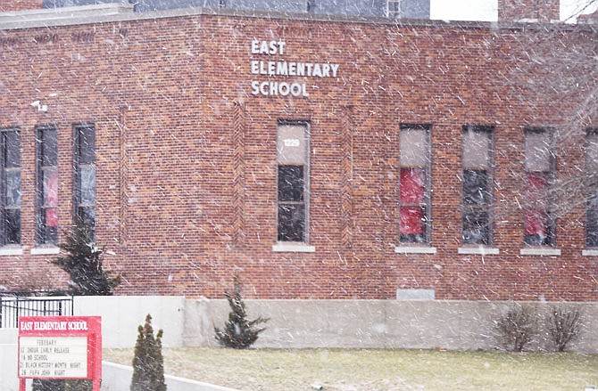 Snow falls Thursday at East Elementary School. With the harsh winter weather this season, area school districts are facing tough choices as the number of snow days runs out.