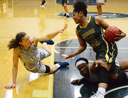 Lincoln teammates Alecia Gulledge (left) and Kaloni Pryear battle with KeShara Scott of Missouri Western for control of the ball during Thursday night's game at Jason Gym.