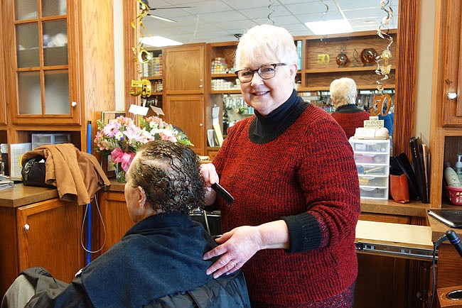 Sandy Ferguson celebrated her 50th anniversary of cutting hair Friday at Salon Studio. Regulars, including Sue Wilson, left, and family members gathered at the salon to enjoy baked goods and punch.