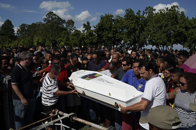 Friends and relatives carry the coffin containing the remains of the young soccer player Arthur Vinicius, one of the victims of a fire at a Brazilian soccer academy, during his burial in Volta Redonda, Brazil, Saturday, Feb. 9, 2019.  A fire early Friday swept through the sleeping quarters of an academy for Brazil's popular professional soccer club Flamengo, killing several and injuring others, most likely teenage players, authorities said. (AP Photo/Leo Correa)