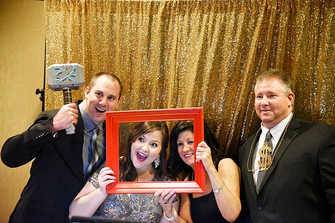 From left, Dan Lensing, Ashley Lensing, Christie Bexten and Shawn Bexten pose for a group photo at the 28th annual Mid-Missouri Heart Ball on Saturday at the Capitol Plaza Hotel. The event included a photo booth with several props for guests to choose from.