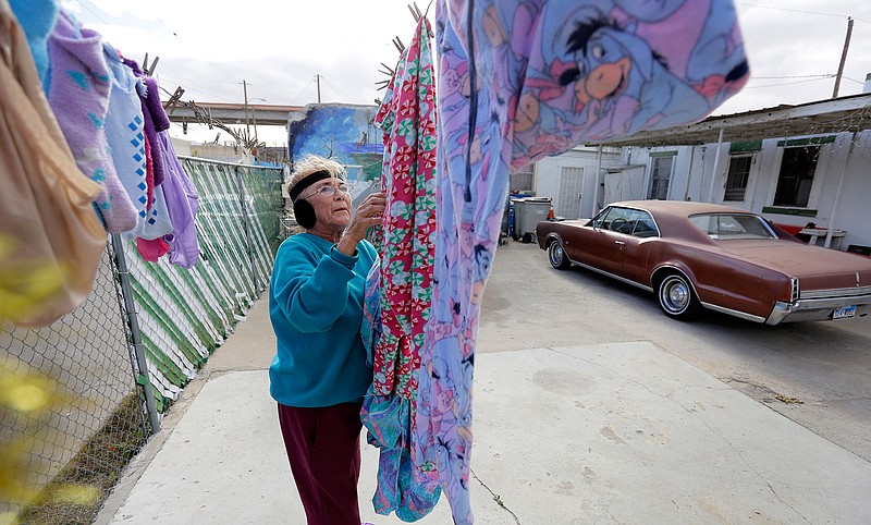 Mickie Subia gathers her laundry Jan. 22, 2019, at her home in El Paso, Texas. Subia lives less than a block away from a border barrier that runs along the Texas-Mexico border in El Paso.