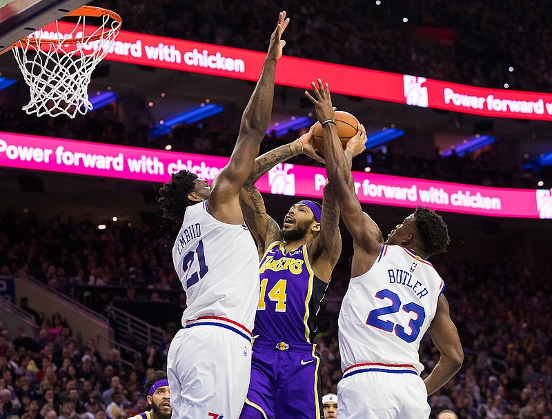 Los Angeles Lakers' Brandon Ingram, center, goes up for the shot against Philadelphia 76ers' Joel Embiid, left, and Jimmy Butler, right, on Sunday during the first half of an NBA game in Philadelphia. 