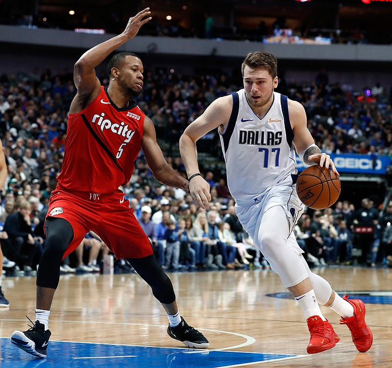 Portland Trail Blazers' Rodney Hood (5) defends as Dallas Mavericks forward Luka Doncic (77) drives to the basket for a shot in the first half of an NBA game Sunday in Dallas.