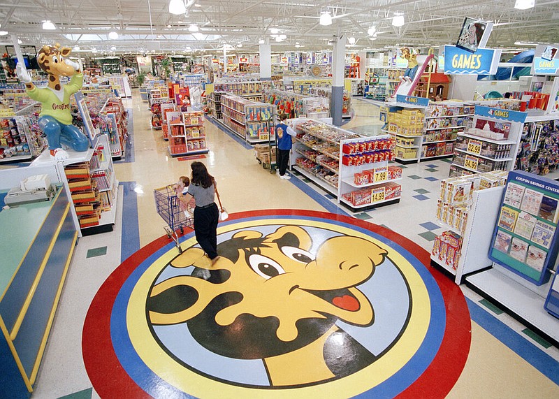 In this July 30, 1996, file photo, a woman pushes a shopping cart over a graphic of Toys R Us mascot Geoffrey the giraffe at the Toys R Us store in Raritan, N.J. Richard Barry, a former Toys R Us executive and now CEO of the new company called Tru Kids Inc., is exploring freestanding stores, shops within existing stores as well as e-commerce. Tru Kids, owned by former investors of Toys R Us, will manage the Toys R Us, Babies R Us and Geoffrey brands