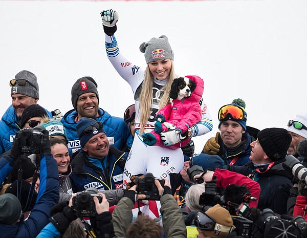 Lindsey Vonn celebrates with a dog, Lucy, after the flower ceremony of the women's downhill race Sunday at the 2019 FIS Alpine Skiing World Championships in Are, Sweden.