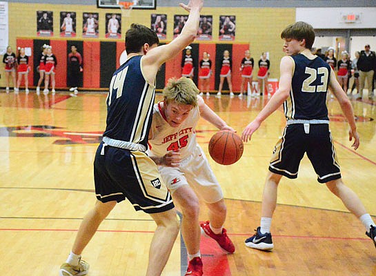 Ryan Brooks of Jefferson City tries to get past Damon Johanns of Helias during Tuesday night's game at Fleming Fieldhouse.