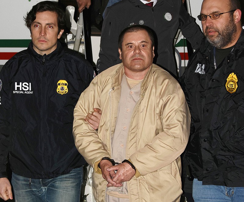 In this Jan. 19, 2017 photo provided by the United States Drug Enforcement Administration, authorities escort Joaquin "El Chapo" Guzman, center, from a plane to a waiting caravan of SUVs at Long Island MacArthur Airport in Ronkonkoma, N.Y. The notorious Mexican drug lord was convicted of drug-trafficking charges, Tuesday, Feb. 12 2019, in federal court in New York. (United States Drug Enforcement Administration via AP)