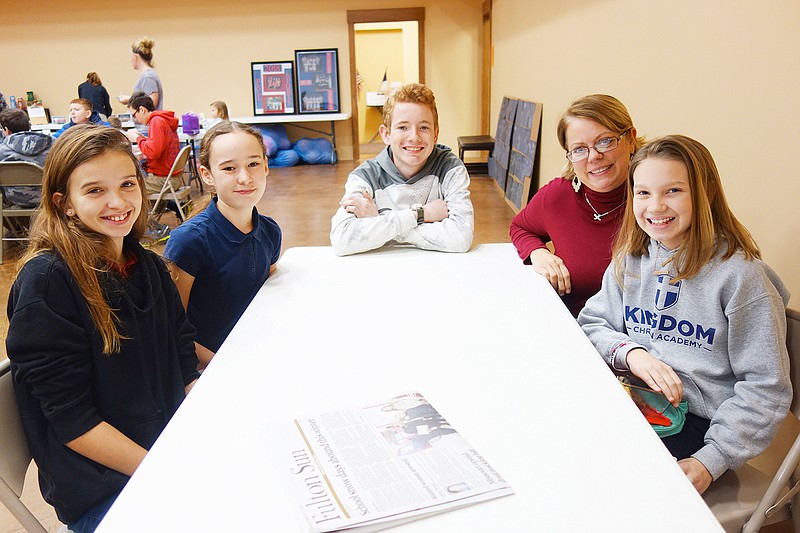 Teghan Sweeney, left, Maddie Hutchison, Silas Parker, teacher Melissa Leisinger and Alysun Phillippe are raising money for families affected by the Evergreen Condos fire.  The students are members of Kingdom Christian Academy's student council.
