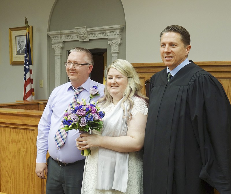 Judge Cotton Walker, right, poses with newly-married couple Travis Owens and Amelia Walker who were married in a brief ceremony Feb. 6 in the Cole County Courthouse.
