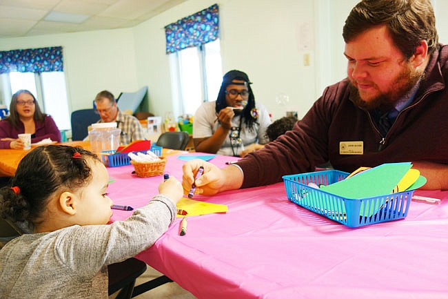 Justin Klocke, from former Sen. Claire McCaskill's office in Columbia, colors with Nora Roizer at Head Start during the 2018 100 Man Lunch. The annual event gives kids a chance to spend time with male role models.