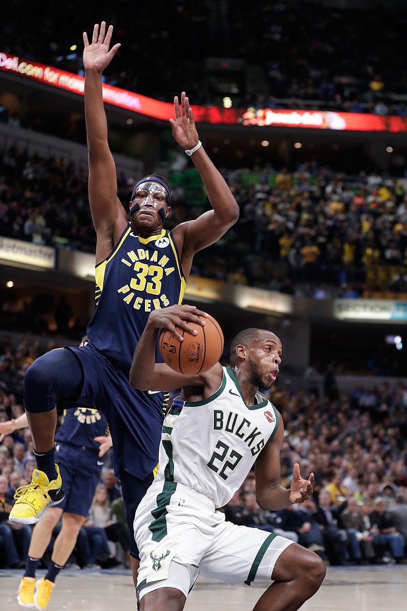 Milwaukee Bucks forward Khris Middleton (22) fakes under Indiana Pacers center Myles Turner (33) during the second half of an NBA basketball game in Indianapolis, Wednesday, Feb. 13, 2019. The Bucks defeated the Pacers 106-97. (AP Photo/Michael Conroy)