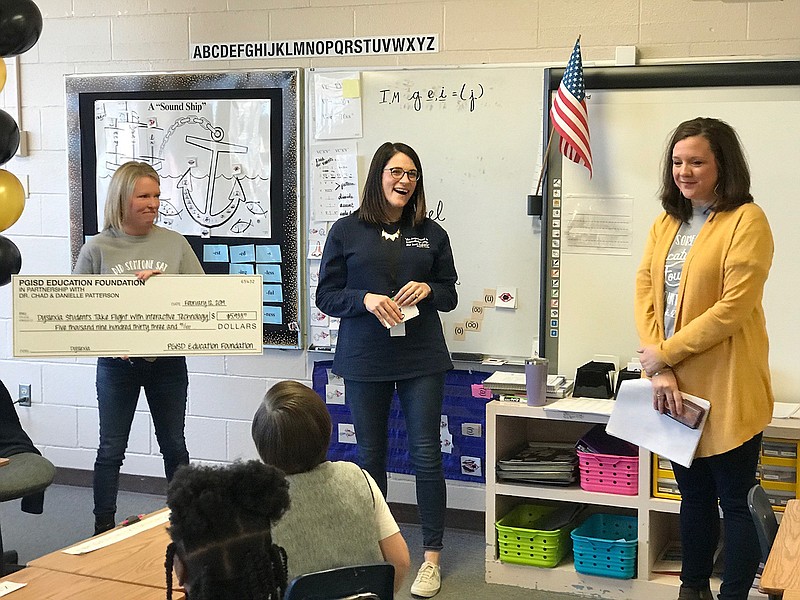 Danielle Patterson and Anna Marie Hornsby with the Pleasant Grove Independent School District Education Foundation present Dyslexia Teacher Kelsey Reynolds with a $5,000 grant for "Dyslexia Students Take Flight." The grant, one of the total $59,732,21 total the foundation awarded Tuesday, will fund enhanced software and technology for the PGISD Dyslexia Department. (Submitted photo)