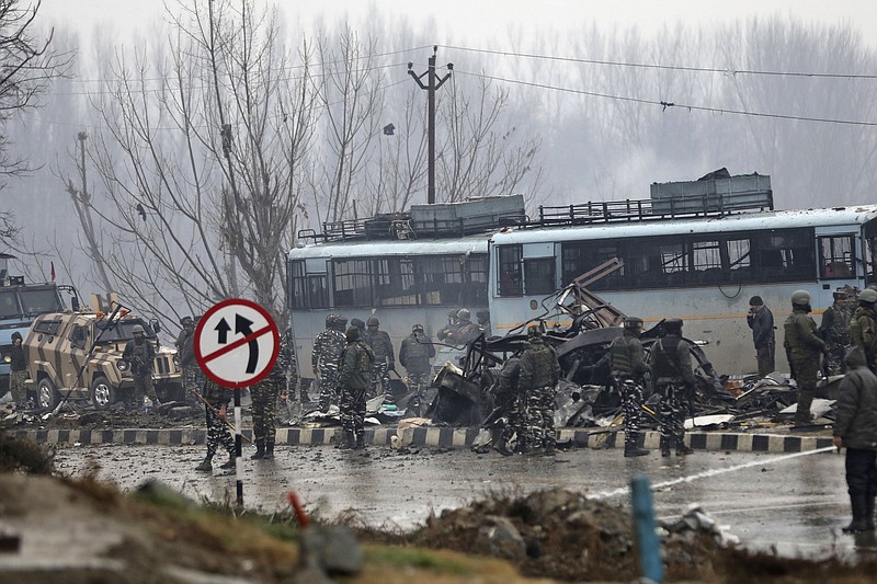 Indian paramilitary soldiers stand by the wreckage of a bus after an explosion in Pampore, Indian-controlled Kashmir, Thursday, Feb. 14, 2019. Security officials say at least 10 soldiers have been killed and 20 others wounded by a large explosion that struck a paramilitary convoy on a key highway on the outskirts of the disputed region's main city of Srinagar. (AP Photo/Umer Asif)