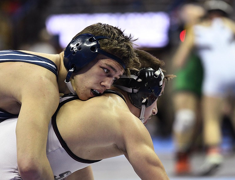 Jackson Careaga of Helias holds on to Sam Frankowski of Rockwood Summit during Saturday's 152-pound title match in the Class 3 state wrestling championships at Mizzou Arena.