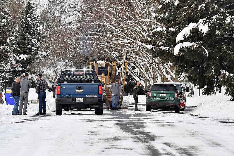 In this Wednesday, Feb. 13, 2019 photo, Spokane County Sheriff's deputies respond to a call where a Spokane County plow driver said a local man brandished a firearm and told him to step out of his plow in Spokane, Wash. Unusually heavy snow in the Spokane area has caused snow plow rage: Two plow drivers clearing streets this week were threatened by people enraged after their driveways ended up blocked with mounds of snow. (Tyler Tjomsland/The Spokesman-Review via AP)