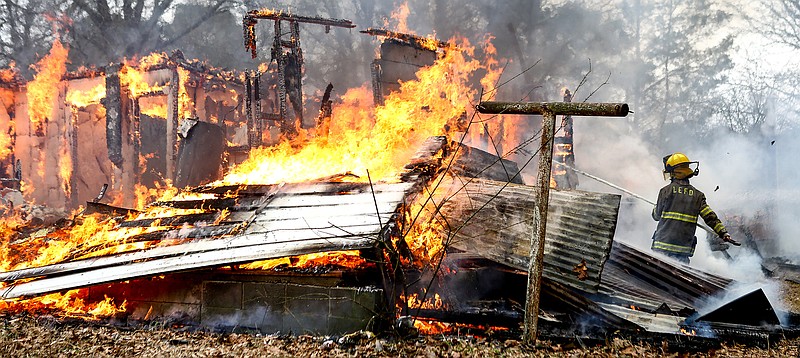 Liberty-Eylau firefighter Colt Freeman takes a break from tring to push down the wall of a burning house to help contain the fire Saturday during a live training exercise on Pleasant Grove Road in Texarkana, Texas. The house's owner needed it to come off and donated it to the Pleasant Grove Fire Department. The department gets the opportunity to do live fire training exercises under controlled conditions and invites surrounding fire departments to participate.
