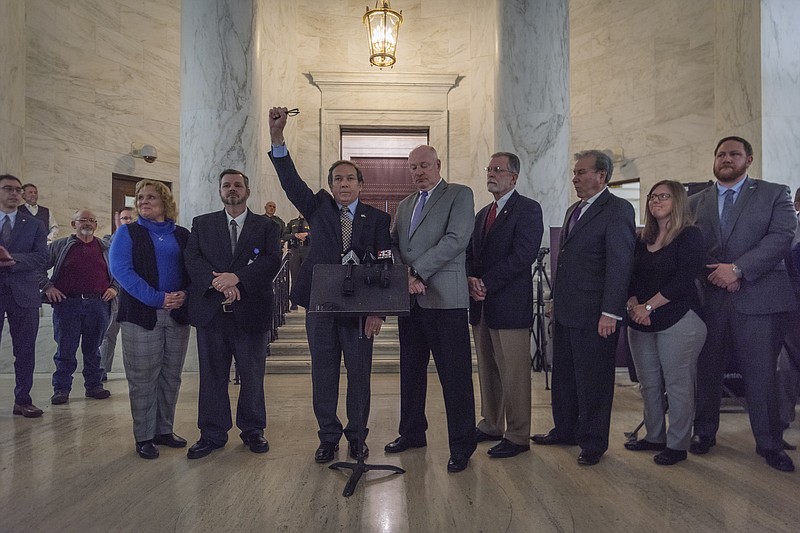 American Federation of Teachers West Virginia Treasurer Fred Albert, fist raised, and other union leaders of the WVEA, AFT-WV and WVSSPA call for a statewide strike beginning tomorrow during a news conference outside of the Senate chamber at the West Virginia State Capitol in Charleston, W.Va., on Monday, Feb. 18, 2019. (Craig Hudson/Charleston Gazette-Mail via AP)