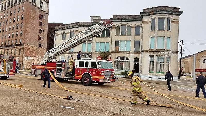 Texarkana, Texas, firefighters gather hoses after extinguishing a fire Wednesday, Feb. 20, 2019, at the Harrell Building, 317 N. State Line Ave. A small fire on the floor of the building is considered suspicious and is under investigation, Texas-side Fire Chief Eric Schlotter said on the scene.