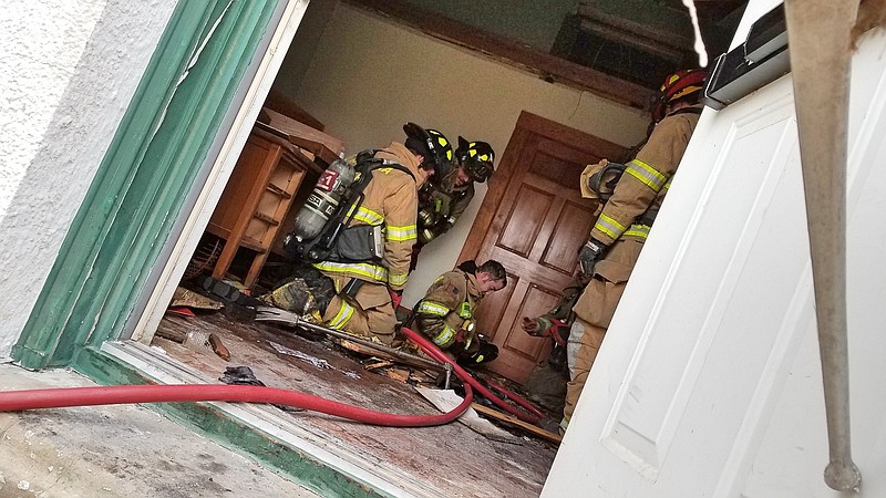 A Texarkana, Texas, firefighter descends through a hole cut in the floor after extinguishing a fire Wednesday, Feb. 20, 2019, at the Harrell Building, 317 N. State Line Ave. The fire was suspicious and is under investigation, Texas-side Fire Chief Eric Schlotter said on the scene.