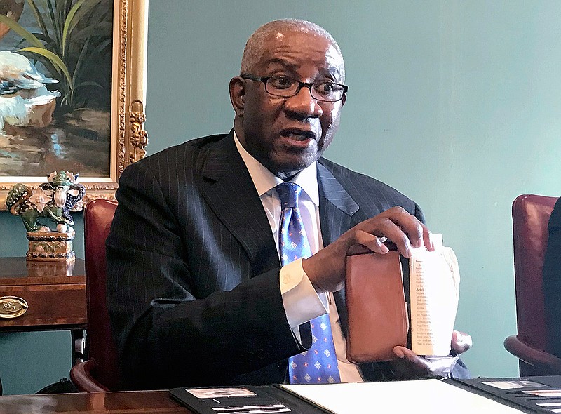 In this Aug. 17, 2018, file photo, Pulaski County Circuit Judge Wendell Griffen holds a copy of the U.S. Constitution at a news conference in Little Rock. (AP Photo/Andrew DeMillo, File)