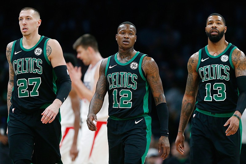 In this Feb. 9, 2019, file photo, Boston Celtics' Daniel Theis (27), Terry Rozier (12) and Marcus Morris (13) walk to the bench during a timeout in the second half of an NBA basketball game against the Los Angeles Clippers, in Boston. The Celtics were expected to challenge the Warriors for the NBA crown, and that could still happen though right now they're looking up at Milwaukee and Toronto in the East. (AP Photo/Michael Dwyer, File)