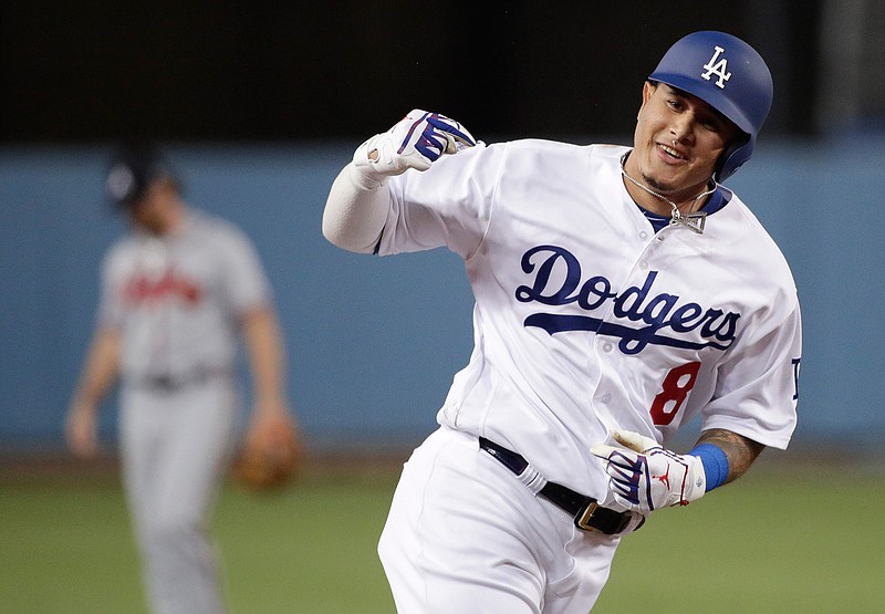 In this Oct. 5, 2018, file photo, then-Los Angeles Dodgers' Manny Machado celebrates his two-run home run against the Atlanta Braves during the first inning of Game 2 of a baseball National League Division Series, in Los Angeles. A person familiar with the negotiations tells The Associated Press that infielder Manny Machado has agreed to a $300 million, 10-year deal with the rebuilding San Diego Padres, the biggest contract ever for a free agent. The person spoke to the AP on condition of anonymity Tuesday, Feb. 19, 2019,  because the agreement was subject to a successful physical and had not been announced. (AP Photo/Jae C. Hong, File)