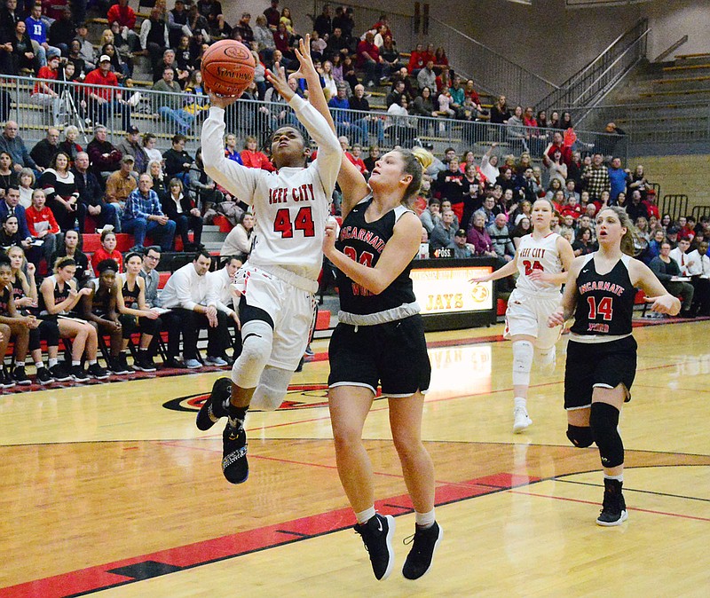 Caitlin Anderson of the Lady Jays leaps to put up a layup as Kiki Britzmann of Incarnate Word defends during Wednesday night's game at Fleming Fieldhouse.