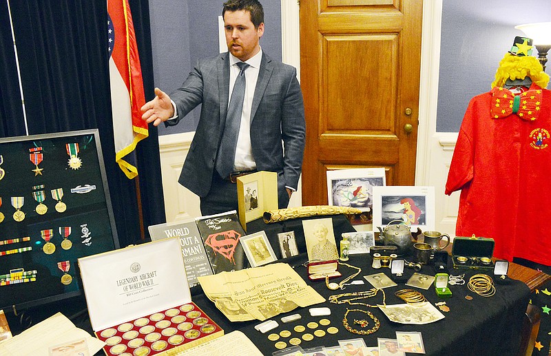 Treasurer Scott Fitzpatrick shows some of the unclaimed properties from safe deposit boxes Wednesday at the state Treasurer's office. Old baseball cards, watches, medals and even an old clown suit were on display.
