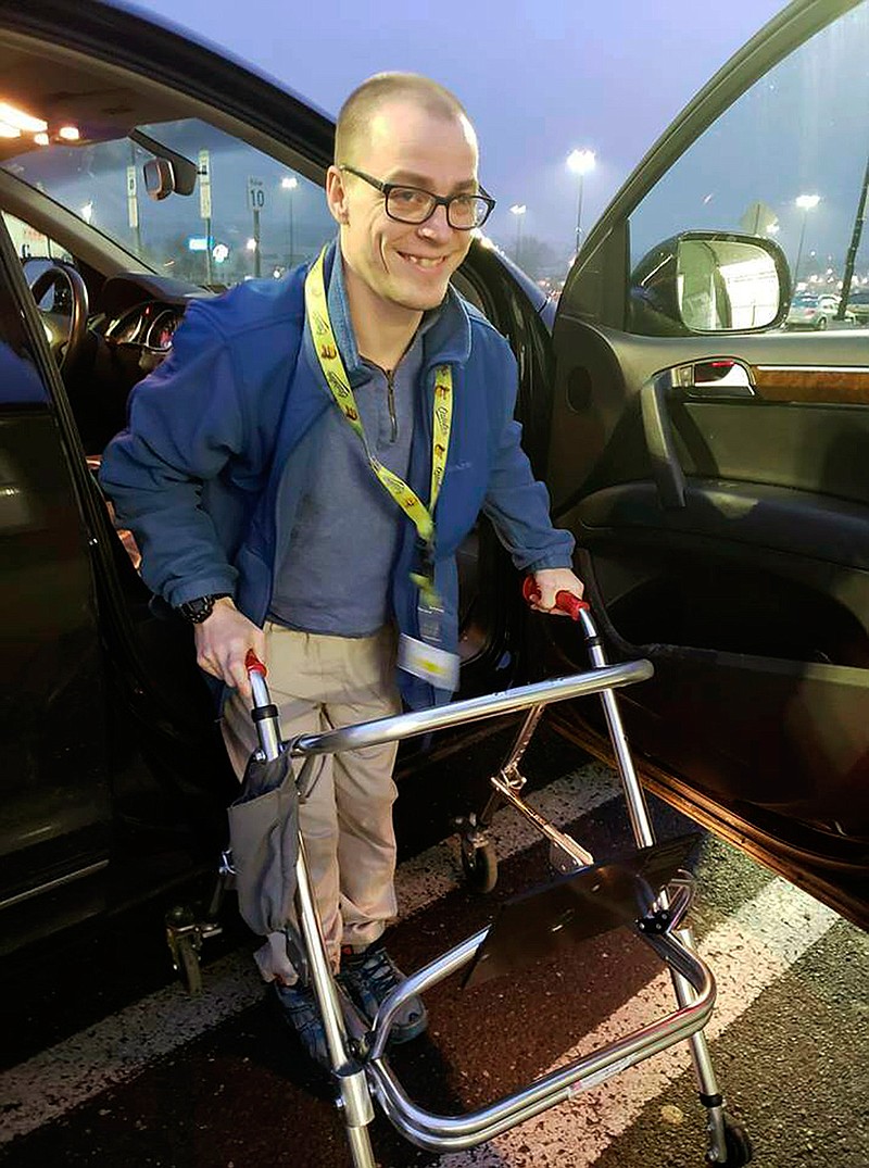 In this Dec. 14, 2018 photo provided by Holly Catlin, Adam Catlin gets out of a car before starting his shift at a Walmart in Selinsgrove, Pa. Catlin, who has cerebral palsy, is afraid he'll be out of work after store officials changed his job description to add tasks that he's physically unable to do. (Holly Catlin via AP)