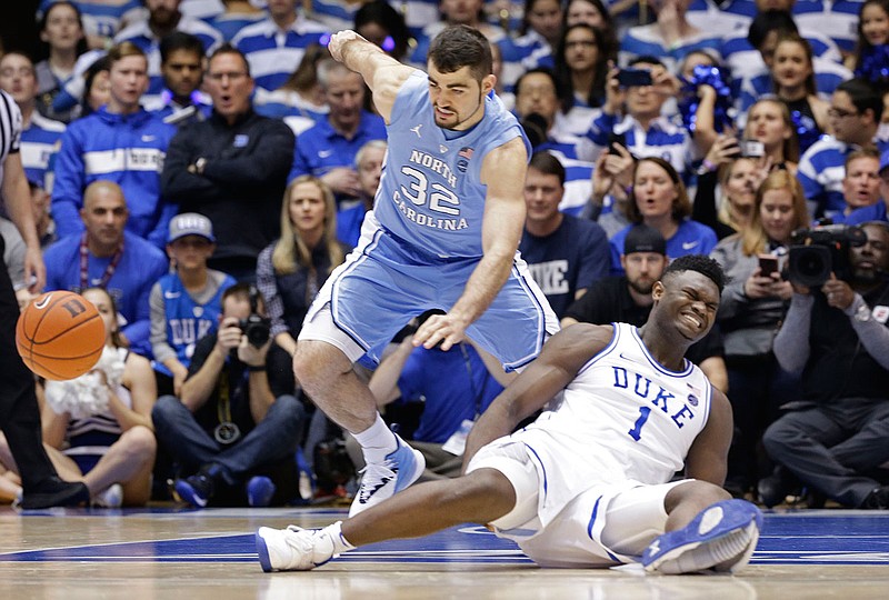 Duke's Zion Williamson falls to the floor with an injury while North Carolina's Luke Maye chases after the ball during Wednesday night's game in Durham, N.C.