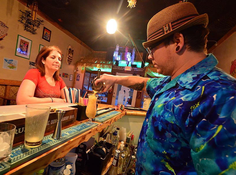 Mark Wilson/News Tribune
Justin Solum mixes drinks for owner Tiffany Hildebrand at the Shrunken Head Tropic Lounge Friday. Shrunken Head Tropic Lounge is closing its bar location and will focus on its liquor catering business. Saturday is their last day. 