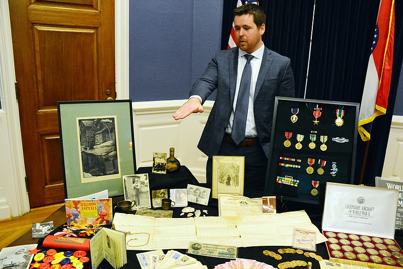 FEBRUARY 2019 FILE: Treasurer Scott Fitzpatrick shows some of the unclaimed properties from deposit boxes at the State Treasurer's office. Old baseball cards, watches, medals and even an old clown suit were on display.