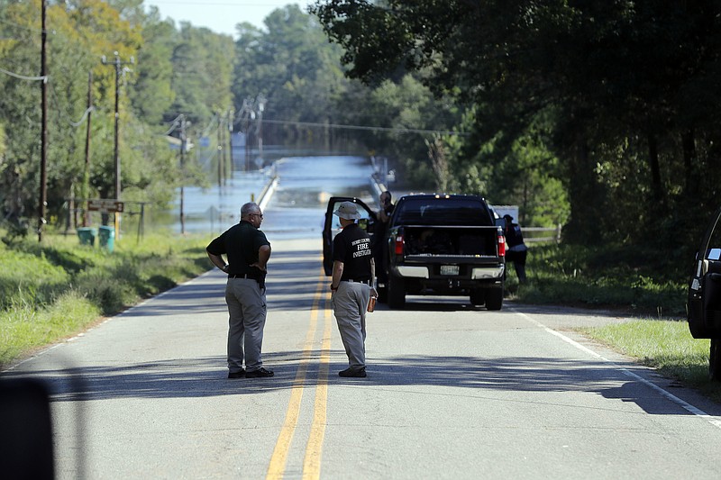 FILE - In this Wednesday, Sept. 19, 2018, file photo, responders congregate near where two people drowned the evening before when they were trapped in a Horry County Sheriff's transport van while crossing an overtopped bridge over the Little Pee Dee River on Highway 76, during rising floodwaters in the aftermath of Hurricane Florence in Marion County, S.C.  South Carolina lawmakers are discussing whether to create a specially trained  police team in the state Department of Mental Health to transport mental patients in the wake of the deaths of the women.(AP Photo/Gerald Herbert, File)
