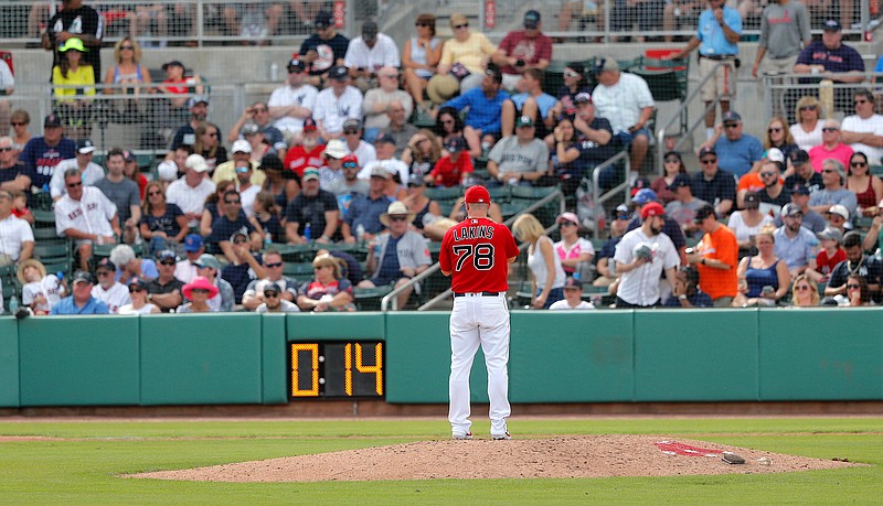 Boston Red Sox pitcher Travis Lakins prepares to pitch as the pitching clock winds down during a spring training baseball game against the New York Yankees in Fort Myers, Fla., Saturday, Feb. 23, 2019. (AP Photo/Gerald Herbert)