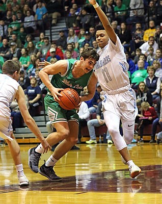 Braydan Pritchett of Blair Oaks drives the lane against Chase Martin of Father Tolton during Saturday afternoon's Class 3 District 9 Tournament championship game in Linn.