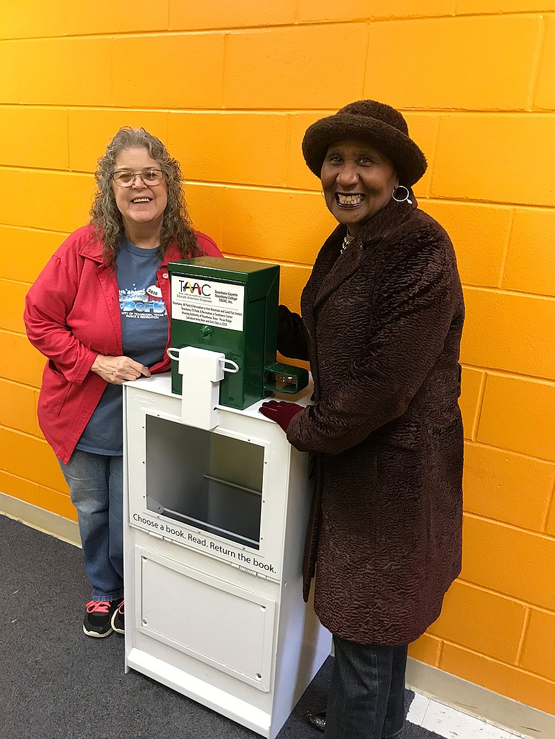 Tammie Moore, left, and Rhonda Dolberry pose with the free little library that will be dedicated Saturday at the Southwest Center in Texarkana, Texas. The library is a repurposed newspaper vending machine donated by the Texarkana Gazette. (Submitted photo)

