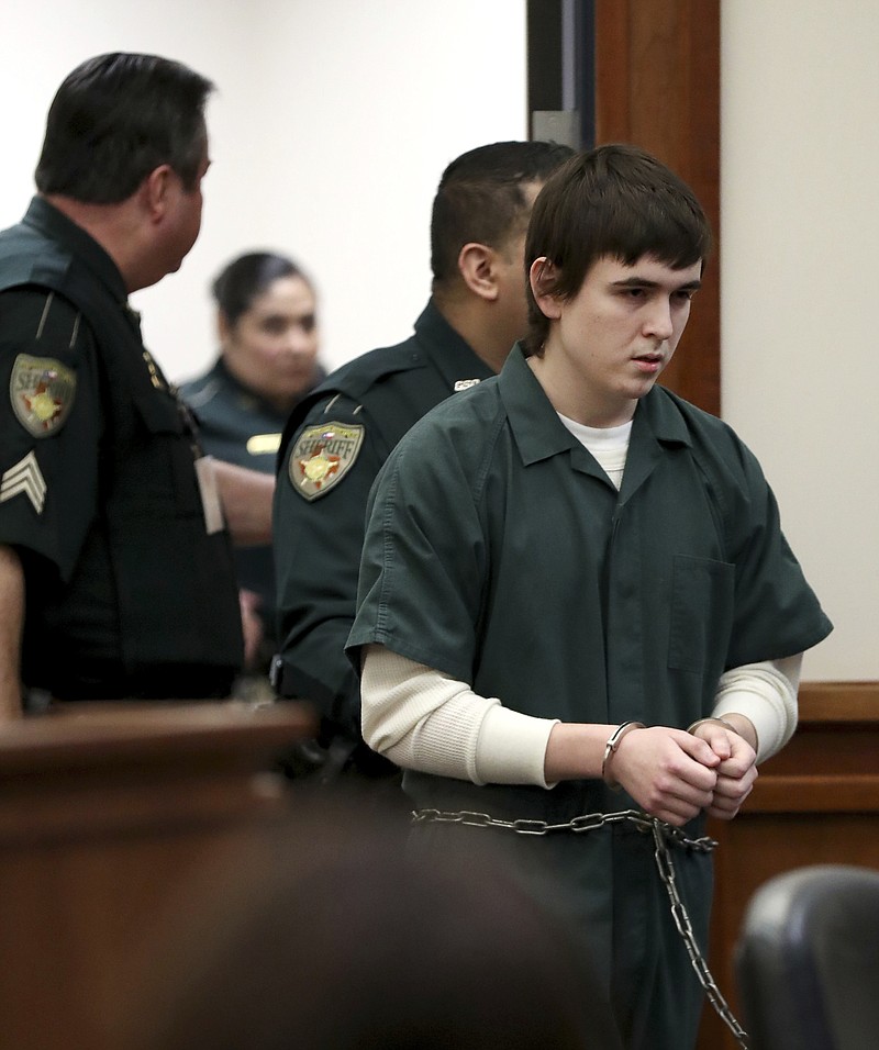 Dimitrios Pagourtzis, the Santa Fe High School student accused of killing 10 people in a May 18 shooting at the high school, is escorted by Galveston County Sheriff's Office deputies into the jury assembly room for a change of venue hearing at the Galveston County Courthouse in Galveston, Texas on Monday, Feb. 25, 2019. The trial of Pagourtzis may be delayed for a year as federal investigators have yet to deliver key evidence, prosecutors said Monday.  (Jennifer Reynolds/The Galveston County Daily News via AP, Pool)