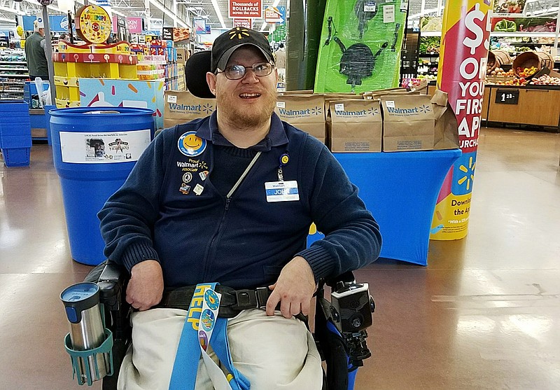 In this April 21, 2018 photo provided by Rachel Wasser, Walmart greeter John Combs works at a Walmart store in Vancouver, Wash. Combs, who has cerebral palsy, and other greeters with disabilities are threatened with job loss as Walmart transforms the greeter position into one that’s more physically demanding. Combs was devastated and then angered by his impending job loss. (Rachel Wasser via AP)