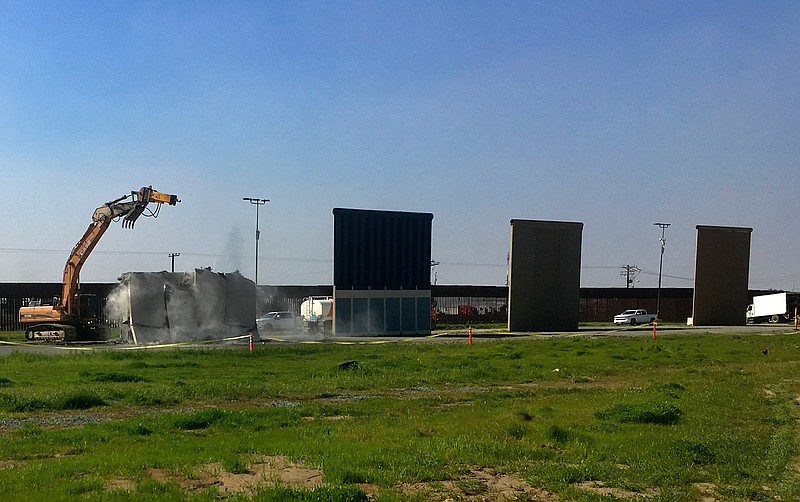 Work crews begin to demolish border wall prototypes in San Diego on Wednesday, Feb. 27, 2019. The Trump administration on Wednesday began to demolish eight prototypes of the president's prized border wall that the government built near San Diego one year ago. (AP Photo/Elliot Spagat)